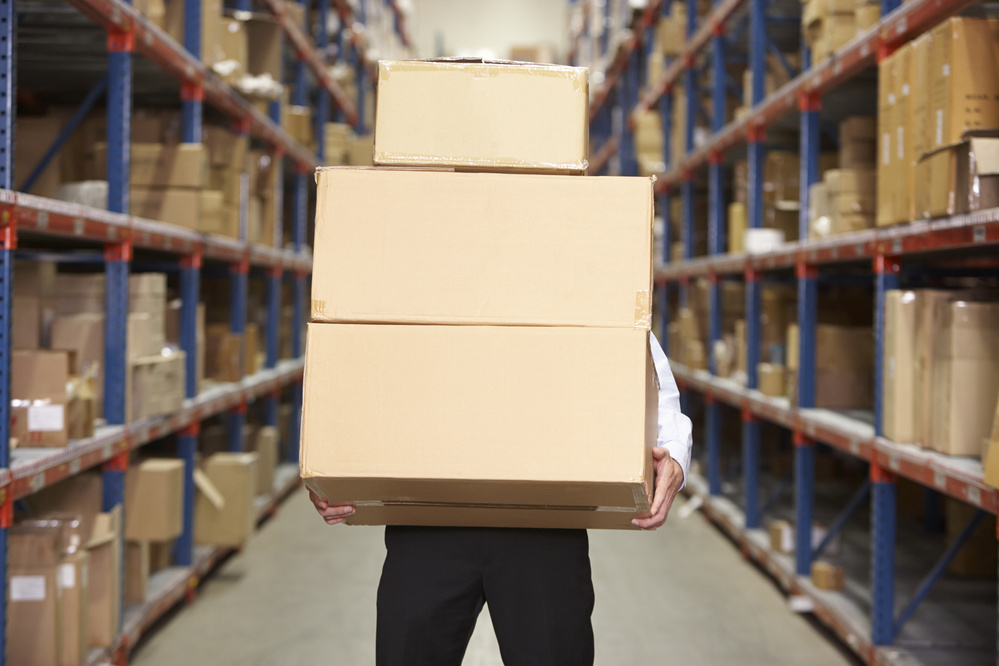 Man Carrying Boxes in Warehouse